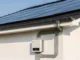 Photovoltaik-Module auf einem Hausdach mit Wechselrichter und Anschlusskabeln für Solarstrom.